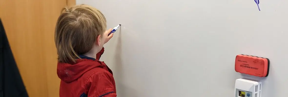 child writing on whiteboard